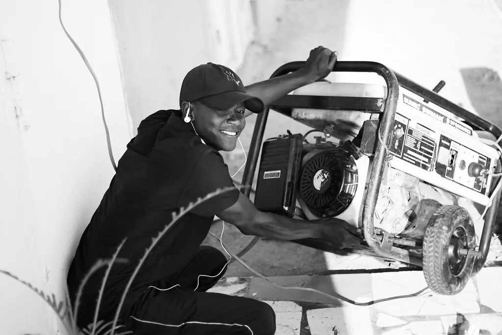 A man starting a portable gas generator outdoors