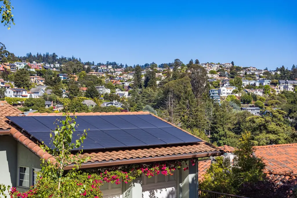 Solar panels on the roof of a hillside home on a sunny day
