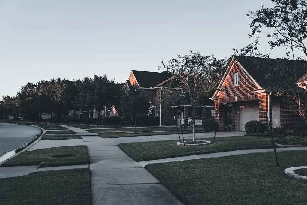 Brick houses and lawns on a quiet suburban street at dusk